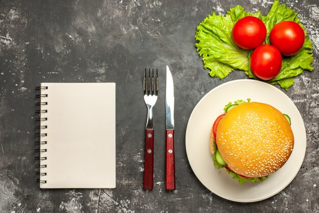 Widok z góry mięsny burger z warzywami i sałatką na ciemnej powierzchni kanapka z bułką fast-food