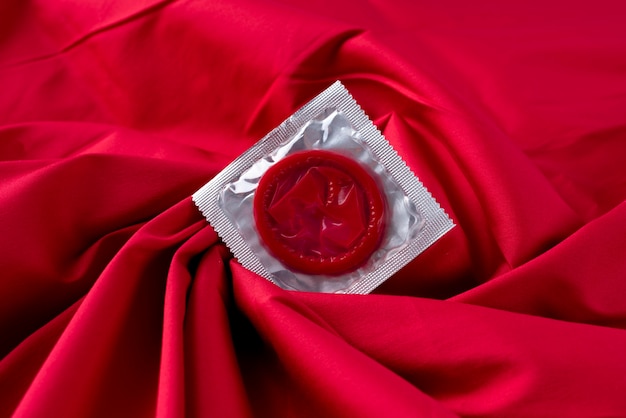 Widok z góry na czerwoną prezerwatywę na prześcieradle