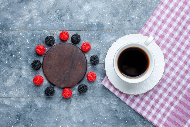 Widok z góry na filiżankę kawy wraz z jagodami konfitur na szarym biurku, słodkie ciasto do pieczenia ciasta cukrowego
