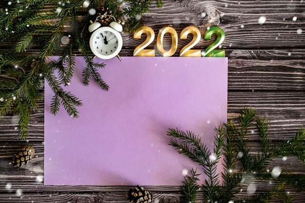 Widok z góry na kartkę z życzeniami szczęśliwego nowego roku, numery 2022, budzik i gałęzie jodły, miejsce bardzo peri kolor