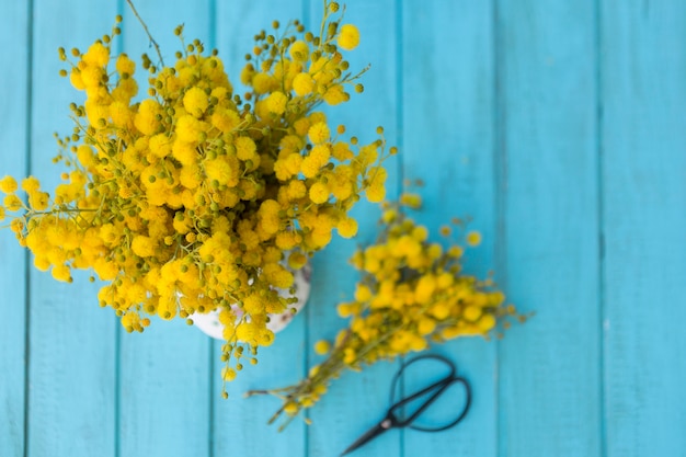 Bezpłatne zdjęcie widok z góry na niebieskim desek z żółtymi kwiatami i nożyczki