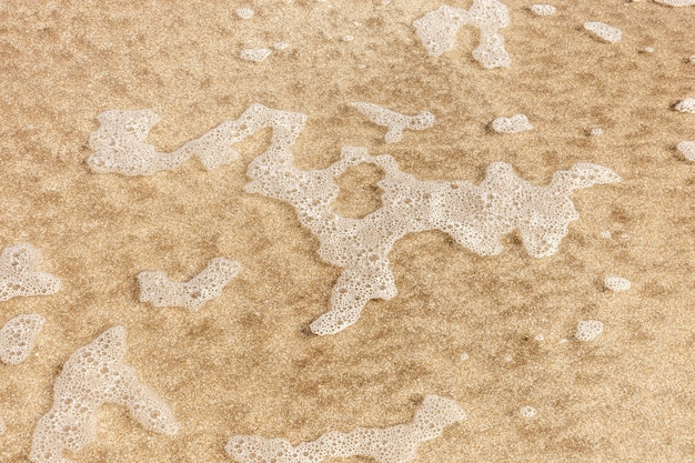 Widok z góry na piasek na plaży z wodą
