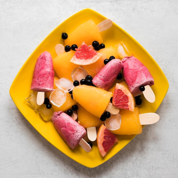 Bezpłatne zdjęcie widok z góry na pyszne lody popsicles na talerzu z owocami i jagodami
