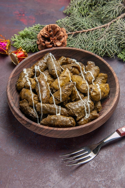 Bezpłatne zdjęcie widok z góry na smaczne danie mięsne dolma z liści wewnątrz brązowego talerza na ciemnej przestrzeni