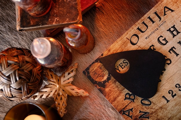 Widok z góry na tablicę ouija i małe butelki