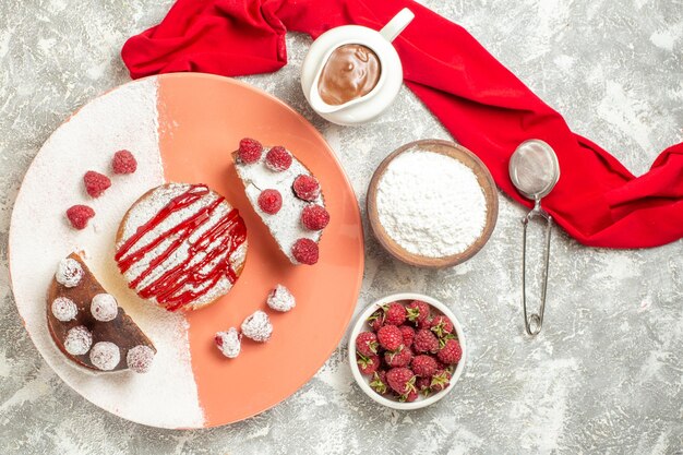 Widok z góry na talerz słodkiego deseru z jagodami z sitka do herbaty czekoladowej i czerwoną serwetką z boku na marmurowym tle