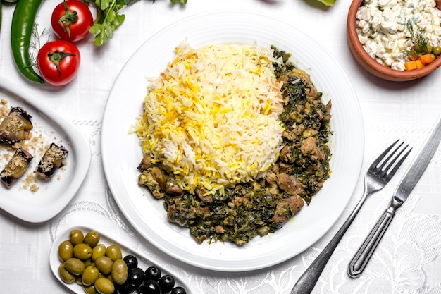 Widok z góry na tradycyjne danie z Azerbejdżanu smażone mięso pilaw syabzi z zieleniną i gotowanym ryżem