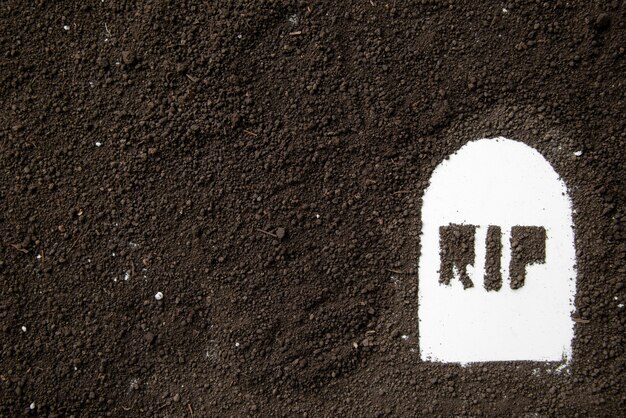 Widok z góry napisu rip na kształcie grobu z ciemną glebą