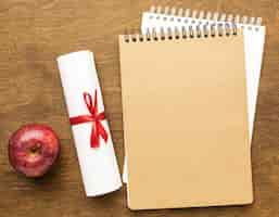 Bezpłatne zdjęcie widok z góry notebooków z dyplomem i jabłkiem
