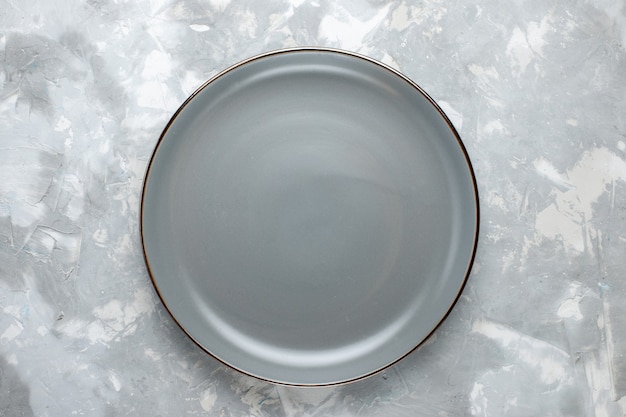 Widok z góry okrągły pusty talerz w kolorze szarym na jasnoszarym talerzu na biurko w kolorze do kuchni