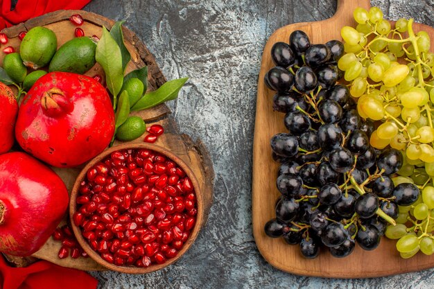 Widok z góry owoce kiście winogron na desce granaty na czerwonym obrusie