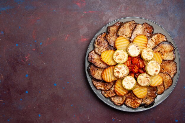 Widok z góry pieczone warzywa, ziemniaki i bakłażany prosto z piekarnika w ciemnym miejscu