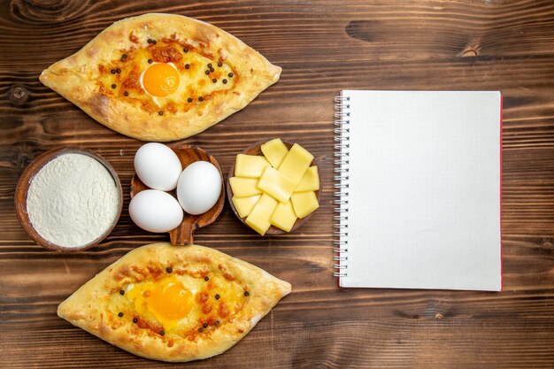 Widok z góry pieczywo jajeczne prosto z pieca na brązowym drewnianym biurku ciasto jajeczne bułki chleb śniadaniowy