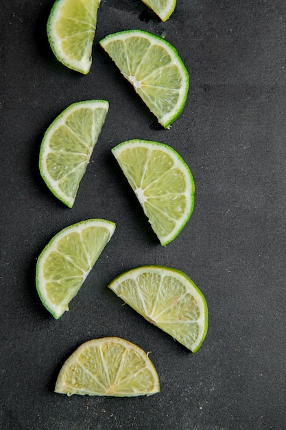 Bezpłatne zdjęcie widok z góry pokrojonych limonek na czarnej powierzchni