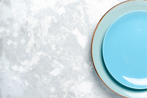 Widok z góry pusty okrągły talerz niebieski ed na jasnobiałym talerzu podłogowym kuchnia sztućce szklane