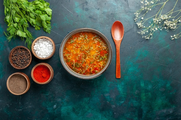 Widok z góry pyszna zupa jarzynowa z przyprawami na zielonym tle żywność składniki warzywa zupa produkt posiłek