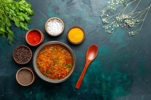Widok z góry pyszna zupa jarzynowa z różnymi przyprawami na ciemnozielonej powierzchni produkt spożywczy posiłek składnik zupa jarzynowa