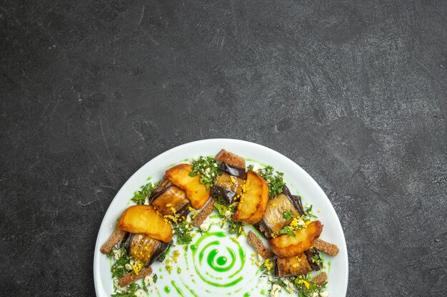 Widok z góry pyszne bułeczki z bakłażana z pieczonymi ziemniakami wewnątrz talerza na ciemnym biurku danie posiłek bułka obiadowa ziemniaczane warzywo