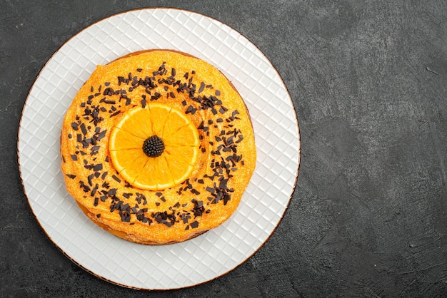 Widok z góry pyszne ciasto z kawałkami czekolady i plasterkami pomarańczy na ciemnej powierzchni ciasto deserowe ciasto herbata herbatniki owocowe