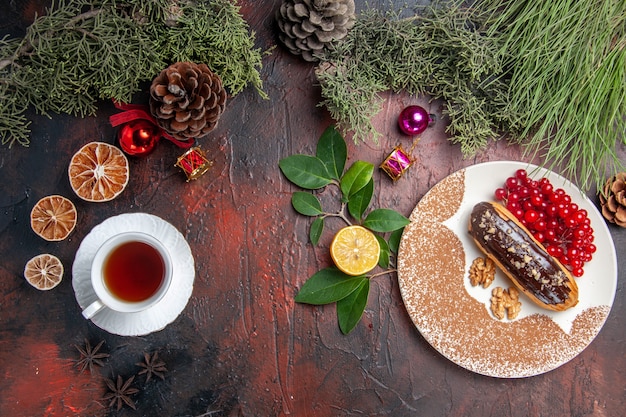 Bezpłatne zdjęcie widok z góry pyszne czekoladowe eklery z herbatą i jagodami na ciemnym stole słodkim tortem deserowym