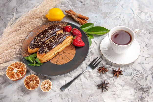 Widok z góry pyszne czekoladowe eklery z truskawkami na herbatniku deserowym z białego ciasta