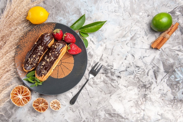 Widok z góry pyszne czekoladowe eklery z truskawkami na herbatniku deserowym z białego ciasta