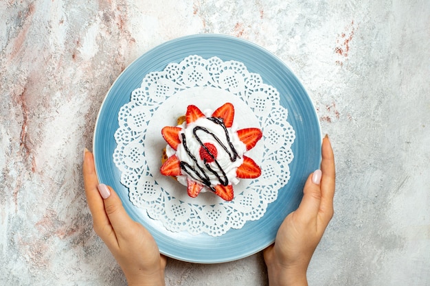 Bezpłatne zdjęcie widok z góry pyszne małe ciasto ze śmietaną i truskawkami na białym tle