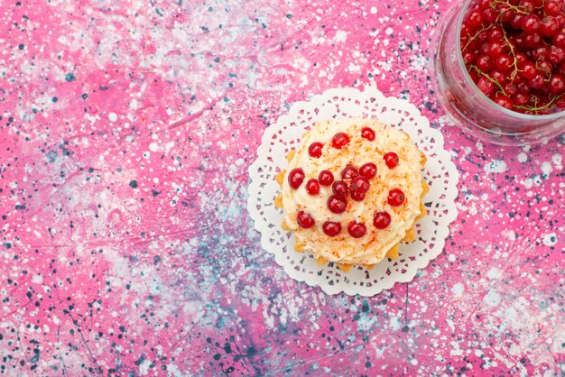 Widok z góry pyszne okrągłe ciasto ze śmietaną i świeżą czerwoną żurawiną na fioletowym cukrze podłogowym