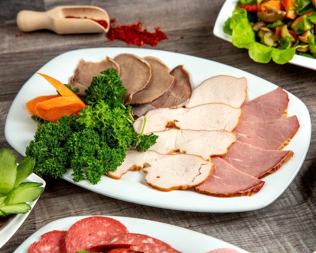 Widok z góry rodzaju kawałków mięsa na talerzu z ziołami i przyprawami na stole