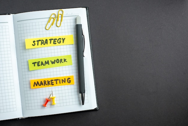 Bezpłatne zdjęcie widok z góry różne notatki biznesowe w notatniku na ciemnym tle biznes plan praca zespołowa strategia przywództwa praca marketingowa wolna przestrzeń