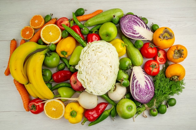 Widok z góry różne warzywa ze świeżymi owocami na jasnym białym tle sałatka jedzenie zdrowie kolor dojrzała dieta