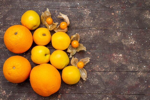 Bezpłatne zdjęcie widok z góry słodkie, łagodne morele pomarańczowe z pomarańczami i fizalizujące pyszne letnie owoce na brązowym tle ciasto owoce świeże zdjęcie