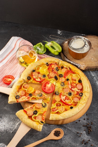 Widok z góry smaczna serowa pizza z czerwonymi pomidorami, czarnymi oliwkami i kiełbaskami na ciemnym biurku z oliwą i świeżymi pomidorami fast-food zapiekanka włoskiego ciasta