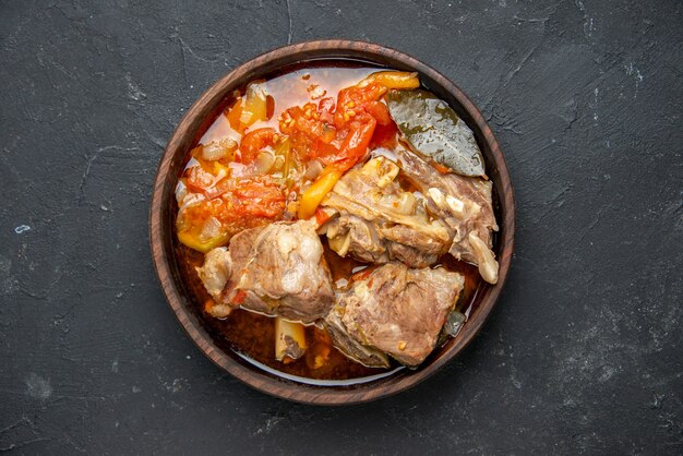 Widok z góry smaczna zupa mięsna z warzywami na ciemnym sosie danie posiłek gorące jedzenie mięso ziemniak kolor zdjęcie obiad kuchnia