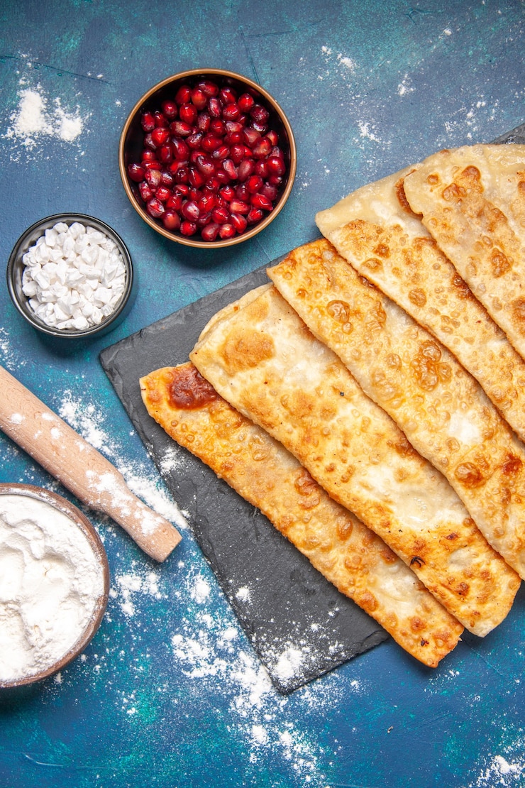 Bezpłatny plik Zdjęcie widok z góry smaczne gutabs cienkie pyszne hotcakes z mięsem na niebieskim tle ciasto piec piekarnik ciasto ciasto jedzenie posiłek hotcake kolor