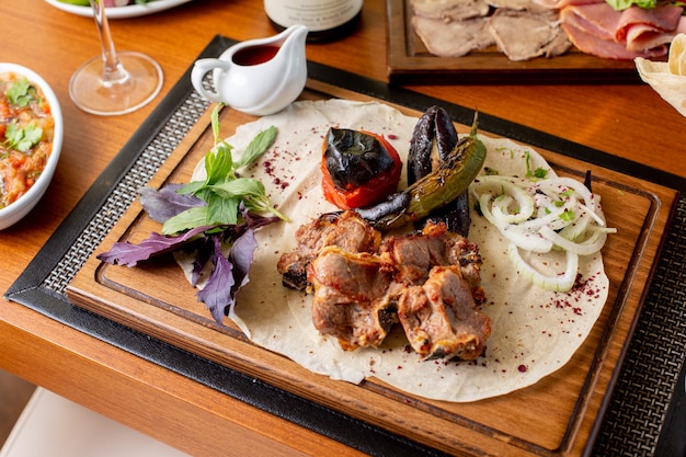 Widok z góry smażone mięso ze smażonymi liśćmi warzyw i sosem na stole restauracja posiłek posiłek