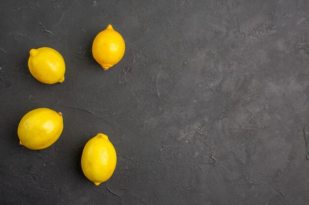 Widok z góry świeże cytryny wyłożone na ciemnym stole owoce cytrusowe żółte wolne miejsce na tekst