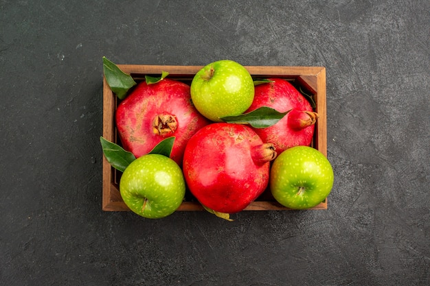 Widok z góry świeże czerwone granaty z zielonymi jabłkami na ciemnej powierzchni kolor dojrzałych owoców