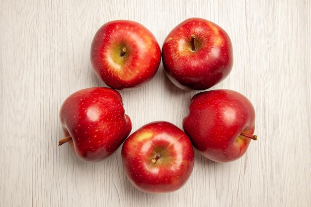 Bezpłatne zdjęcie widok z góry świeże czerwone jabłka aksamitne i dojrzałe owoce na białym biurku kolor owoców świeża roślina czerwone drzewo