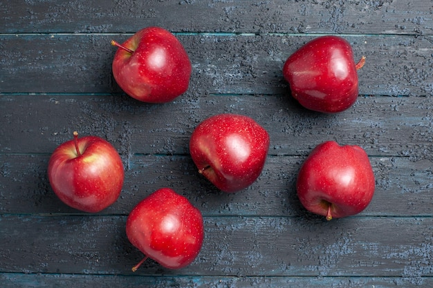 Bezpłatne zdjęcie widok z góry świeże czerwone jabłka aksamitne i dojrzałe owoce na ciemnoniebieskim biurku owoce całe kolory czerwona roślina witamina świeża