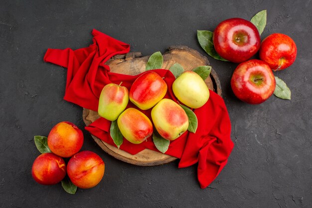 Widok z góry świeże jabłka dojrzałe owoce na czerwonej tkance i szarym stole świeże dojrzałe owoce