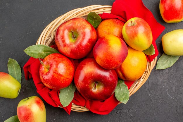 Widok z góry świeże jabłka z brzoskwiniami na ciemnym stole z dojrzałymi sokami owocowymi