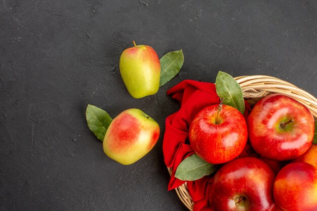 Widok z góry świeże jabłka z brzoskwiniami w koszu na ciemnej podłodze dojrzałe świeże owoce?