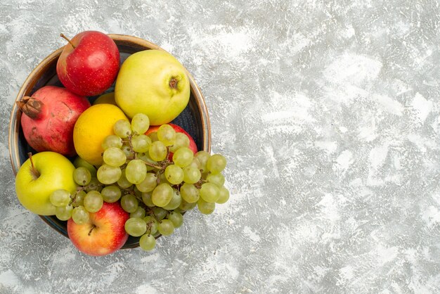 Widok z góry świeże owoce skład jabłka winogrona i inne owoce na białym tle świeże łagodne owoce dojrzałe kolor vitamine