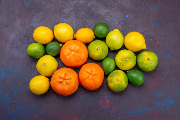 Bezpłatne zdjęcie widok z góry świeże soczyste mandarynki w kolorze pomarańczowym z innymi cytrusami na ciemnym biurku cytrusowe tropikalne egzotyczne pomarańczowe owoce