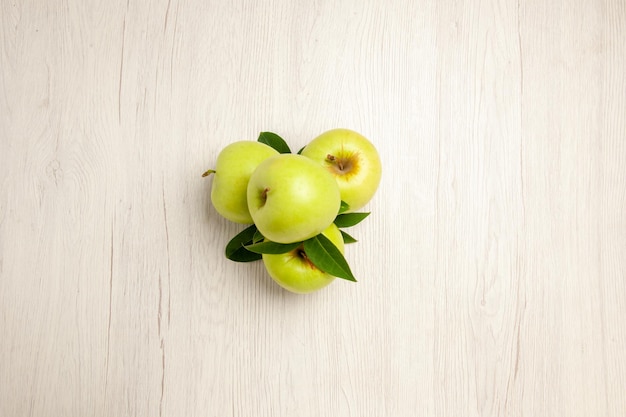 Widok z góry świeże zielone jabłka aksamitne i dojrzałe owoce na białym biurku roślina owocowa kolor świeże zielone drzewo