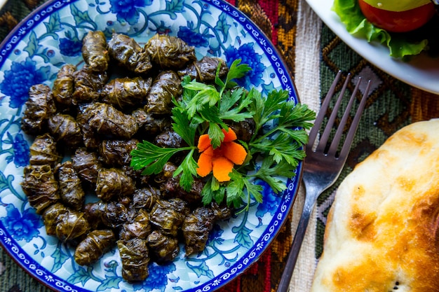 Widok z góry tradycyjnego dań azerskiego mięsa dolma w liściach winogron z natką pietruszki i marchewką. Jpg