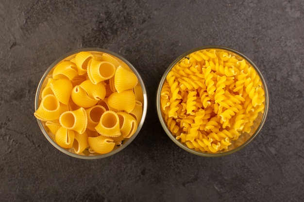 Widok z góry włoski suchy makaron żółty surowe wewnątrz miski odizolowane w ciemności