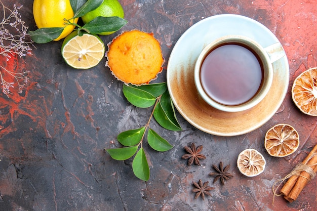 Widok z góry z bliska filiżanka herbaty babeczka filiżanka czarnej herbaty cytryna gwiazdka anyż liście cynamonu gałęzie