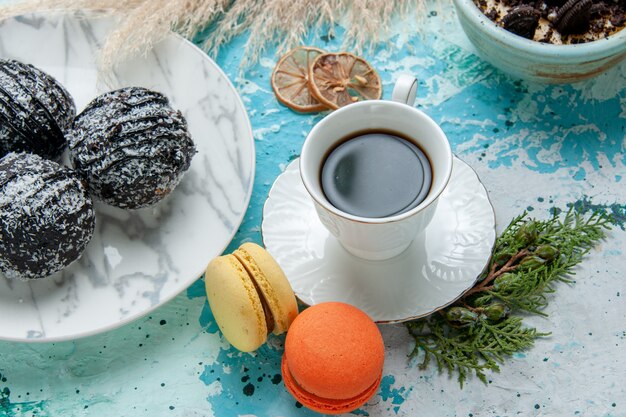 Widok z góry z bliska filiżanka kawy z francuskim ciasteczkiem macarons deser i ciastami czekoladowymi na niebieskiej ścianie ciasto upiec herbatniki słodki cukier czekoladowy kolor